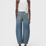 JONES + CO Jazzie barrel jeans in distressed blue denim with a mid-waist, cropped leg, and vintage patched holes.