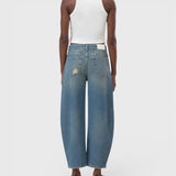 JONES + CO Jazzie barrel jeans in distressed blue denim with a mid-waist, cropped leg, and vintage patched holes.