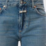JONES + CO Jazzie barrel jeans in distressed blue denim with a mid-waist cut, five pockets, and vintage wash.
