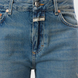 JONES + CO Jazzie barrel jeans in distressed blue denim with a mid-waist cut, five pockets, and vintage wash.