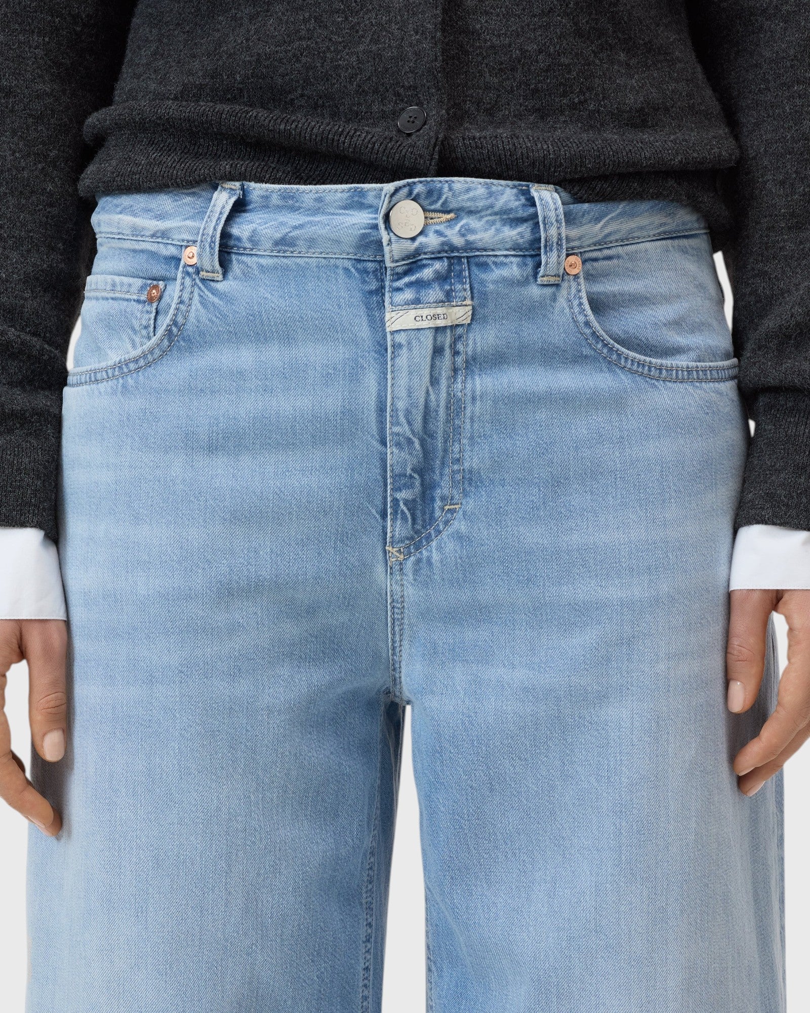 JONES + CO Jazzie barrel jeans in light blue denim with a mid-rise waist, five-pocket design, and button-zip closure.