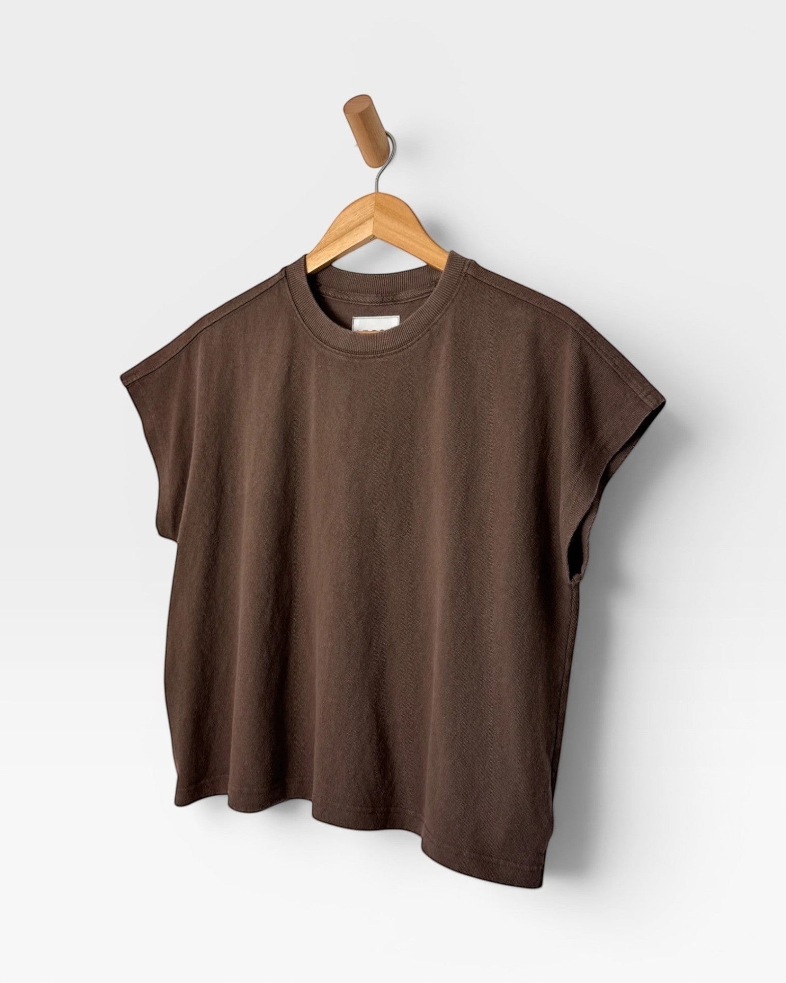 JONES + CO Jeanne muscle tee in chocolate brown with a high crew neck and dolman sleeves hanging on a wooden hanger.