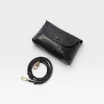 JONES + CO Kaanapali Crossbody in black metallic aniline leather with adjustable strap and brass hardware.