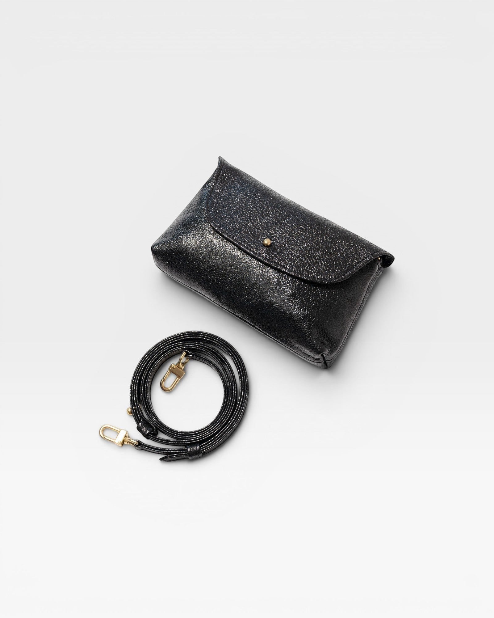 JONES + CO Kaanapali Crossbody in black metallic aniline leather with adjustable strap and brass hardware.