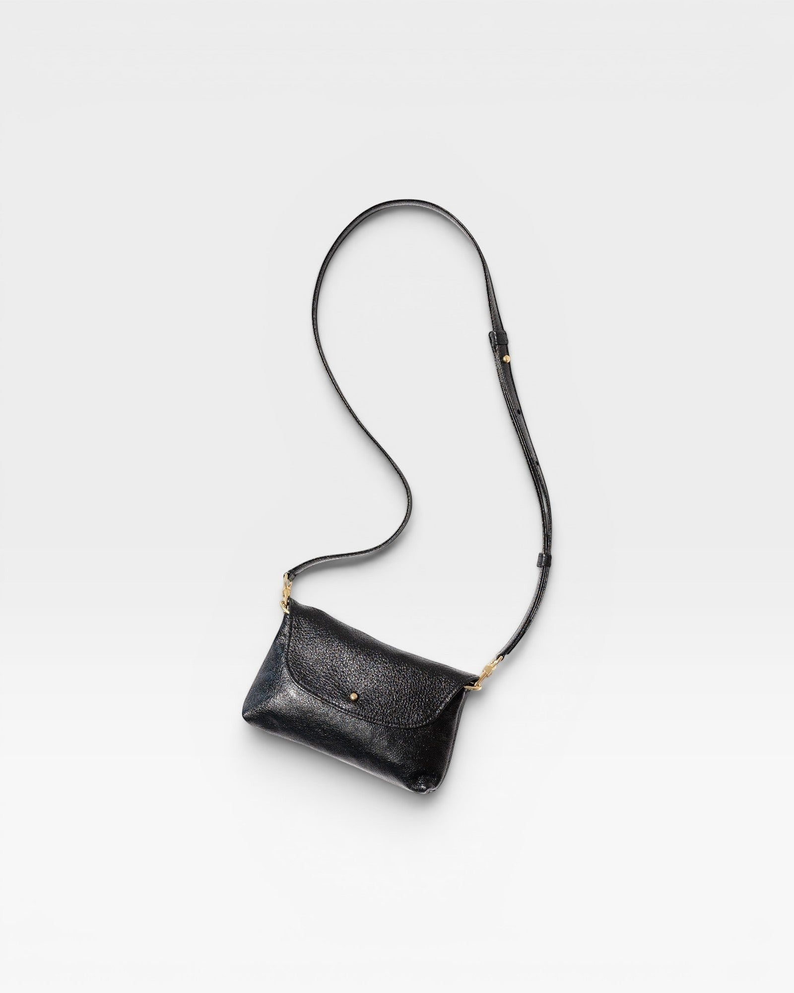 JONES + CO Kaanapali crossbody bag in black metallic aniline leather with adjustable strap and brass hardware.