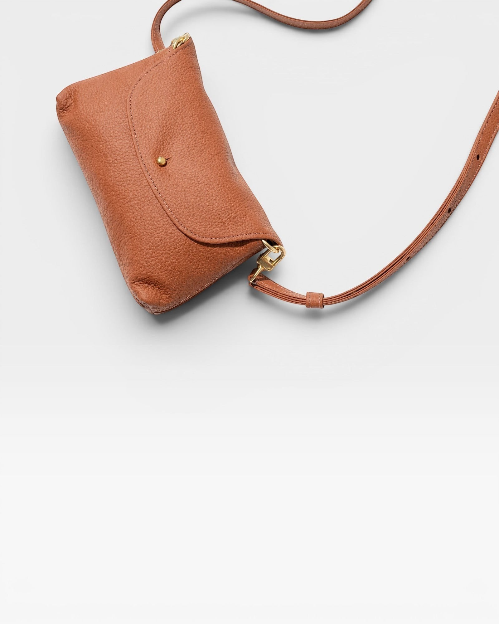 JONES + CO Kaanapali crossbody bag in maple pebble leather with gold-tone hardware and adjustable strap.