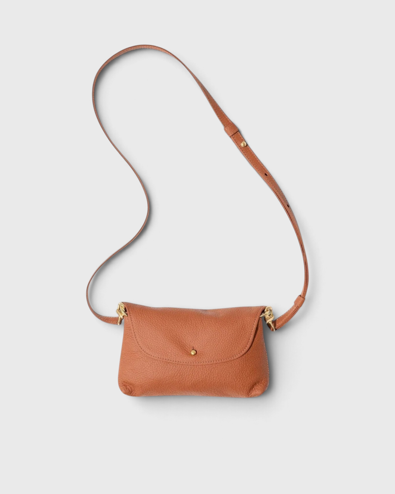 JONES + CO Kaanapali crossbody bag in maple pebble leather with a slim adjustable strap and gold hardware.