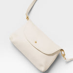 JONES + CO Kaanapali Crossbody in milk pebble leather with gold hardware. Versatile for day or night.
