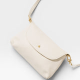 JONES + CO Kaanapali Crossbody in milk pebble leather with gold hardware. Versatile for day or night.