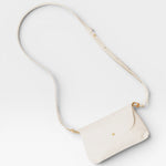 JONES + CO Kaanapali crossbody bag in milk pebble leather with gold hardware and adjustable strap.