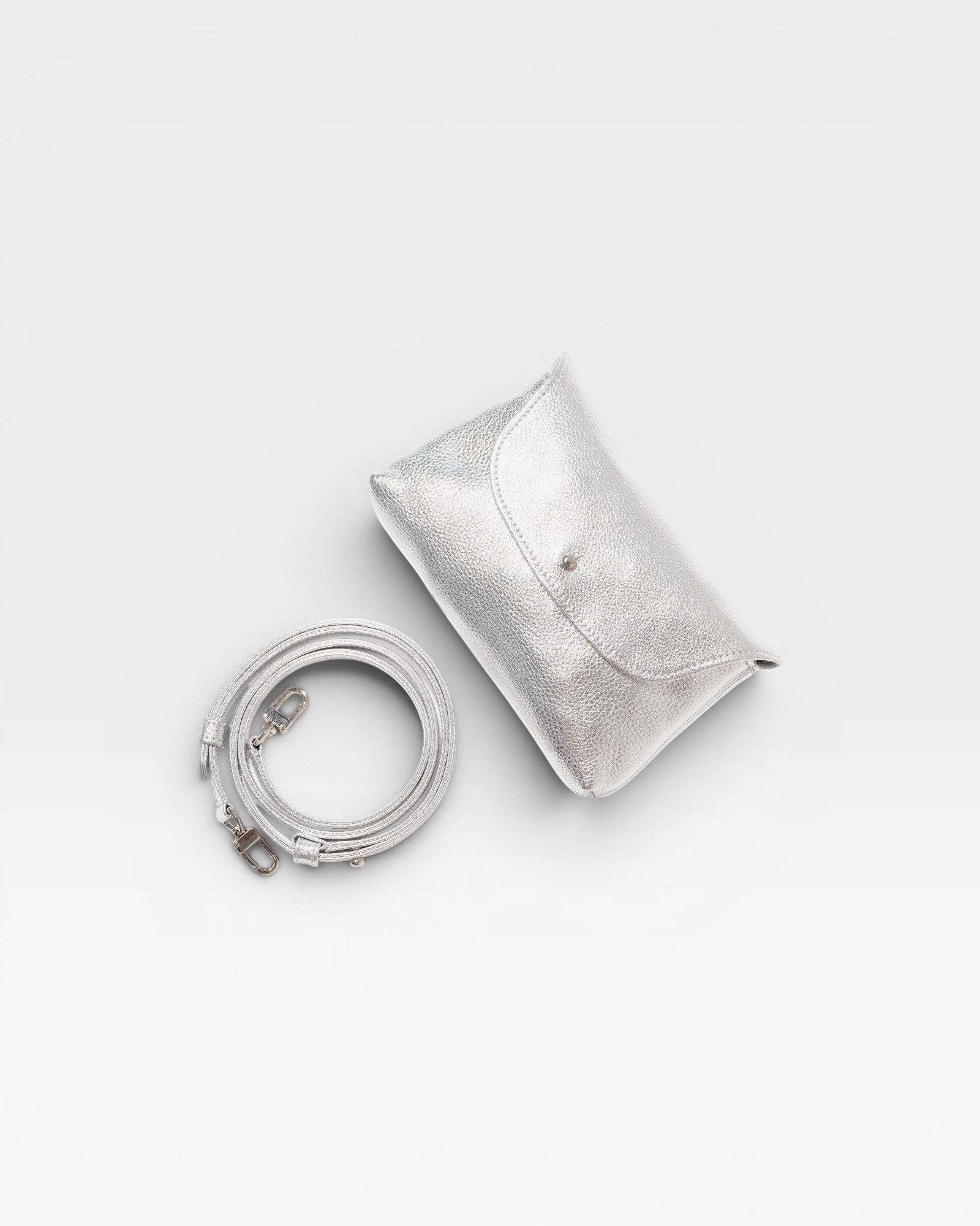 JONES + CO Kaanapali Crossbody in silver metallic aniline leather with detachable strap. Envelope flap closure.