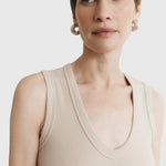 JONES + CO Kana Tank in dune beige featuring a deep scoop neckline and finely ribbed knit fabric on a model