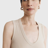 JONES + CO Kana Tank in dune beige featuring a deep scoop neckline and finely ribbed knit fabric on a model
