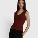 JONES + CO Kana Tank in merlot red, featuring a deep scoop neckline and finely ribbed knit fabric on a model.