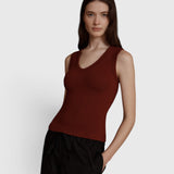 JONES + CO Kana Tank in merlot red, featuring a deep scoop neckline and finely ribbed knit fabric on a model.