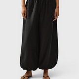 JONES + CO Kortez balloon pants in black viscose satin with an elasticated waist and hem on a model