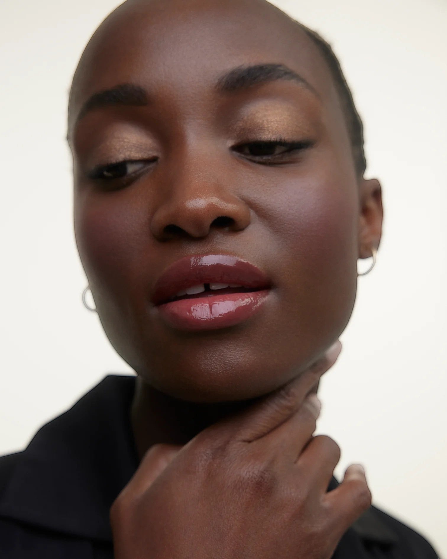 JONES + CO La Laque Tinted Lip Oil in a berry shade, providing sheer luminous color and a glossy finish.