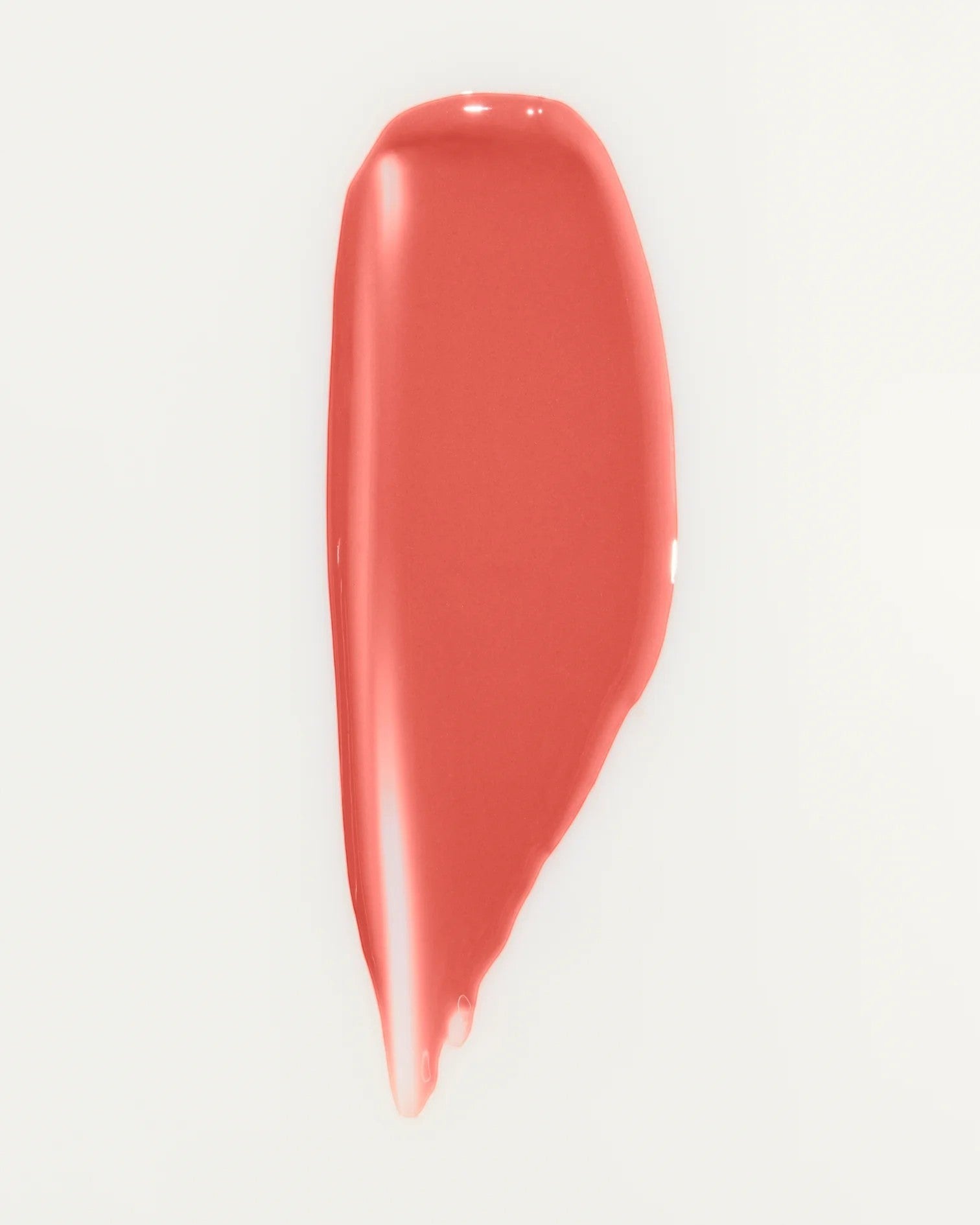 JONES + CO La Laque Tinted Lip Oil in a coral shade, a sheer, luminous, and hydrating lip gloss with a balm-like texture.