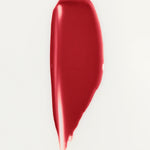 JONES + CO La Laque Tinted Lip Oil in a vibrant red shade, showing a smooth, glossy texture.