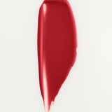 JONES + CO La Laque Tinted Lip Oil in a vibrant red shade, showing a smooth, glossy texture.