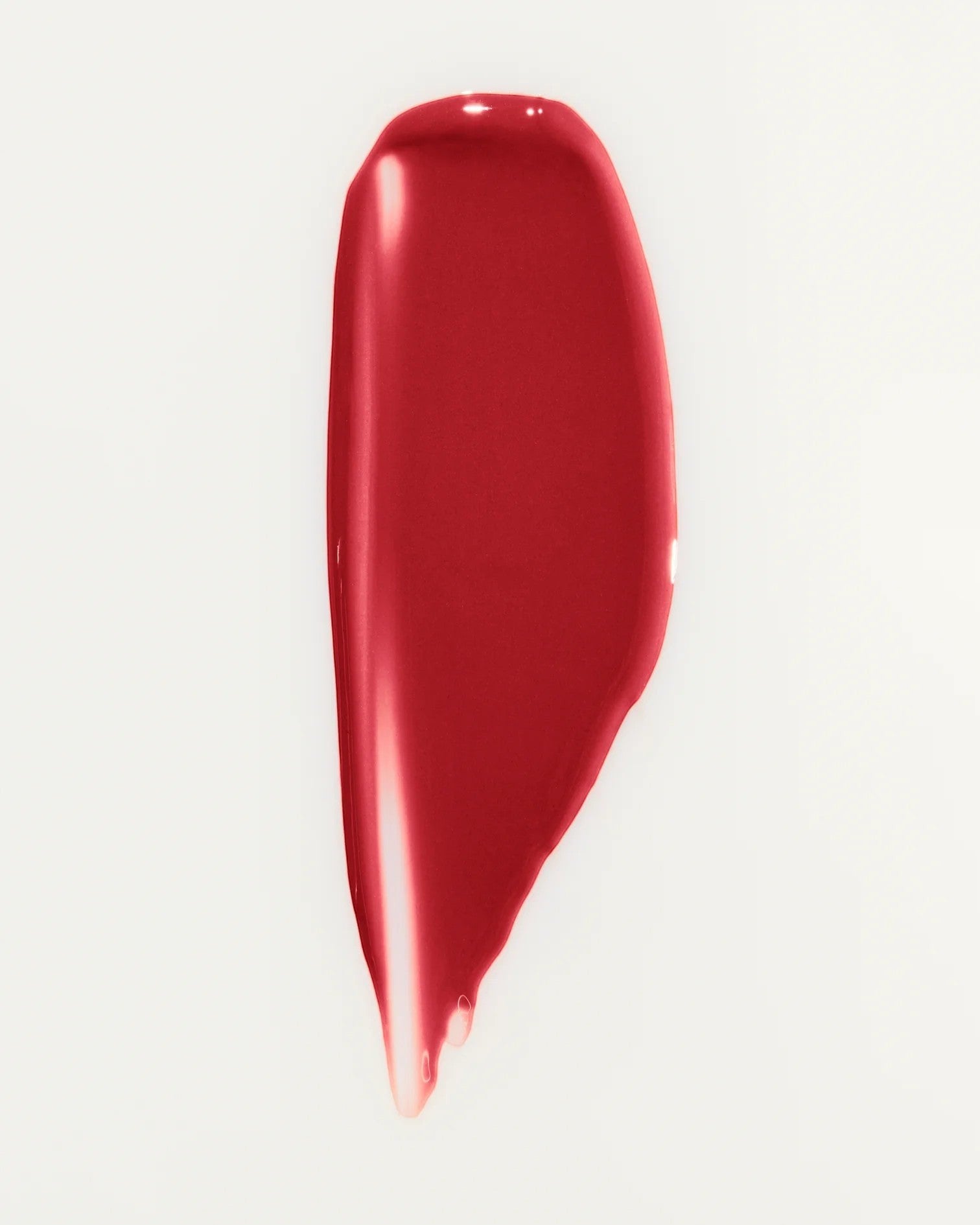 JONES + CO La Laque Tinted Lip Oil in a vibrant red shade, showing a smooth, glossy texture.