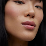 JONES + CO La Laque Tinted Lip Oil in a sheer rosy-pink shade, offering a glossy, balm-like finish.
