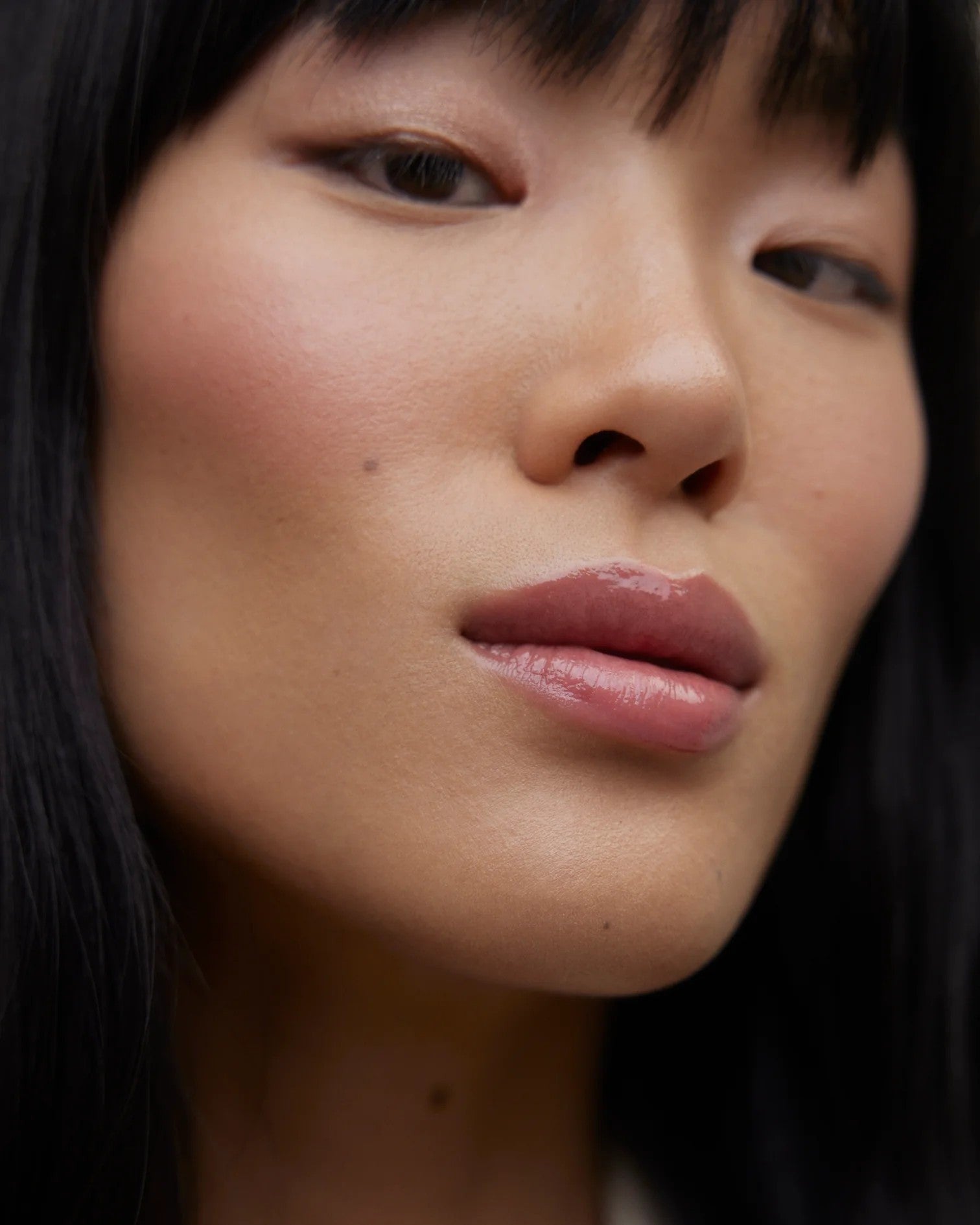 JONES + CO La Laque Tinted Lip Oil in a sheer rosy-pink shade, offering a glossy, balm-like finish.