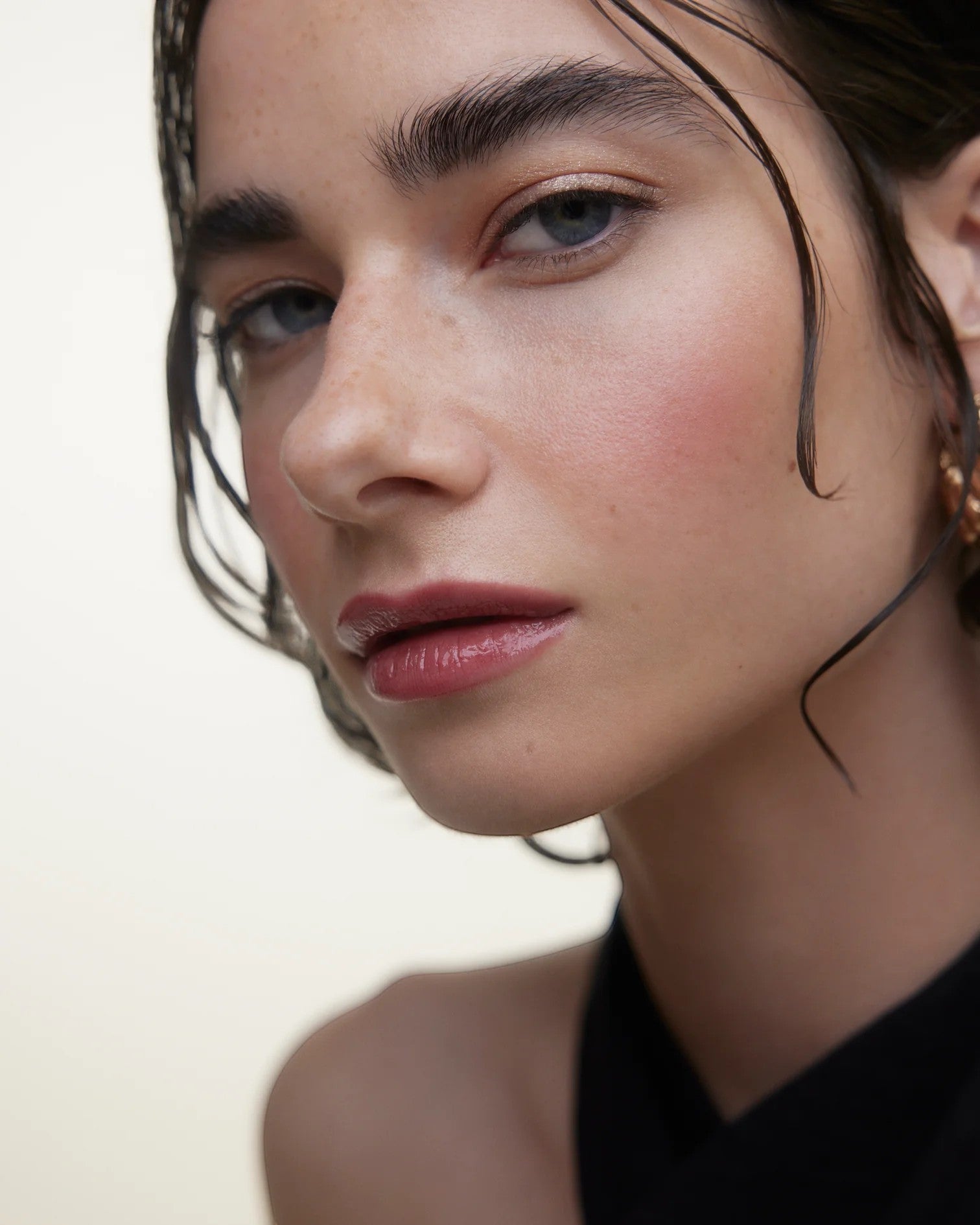 JONES + CO La Laque Tinted Lip Oil in a rosy shade, offering sheer luminous color and a balm-like finish on lips.