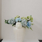 JONES + CO large ceramic vase with unique ash glaze, holding blue and green hydrangeas.