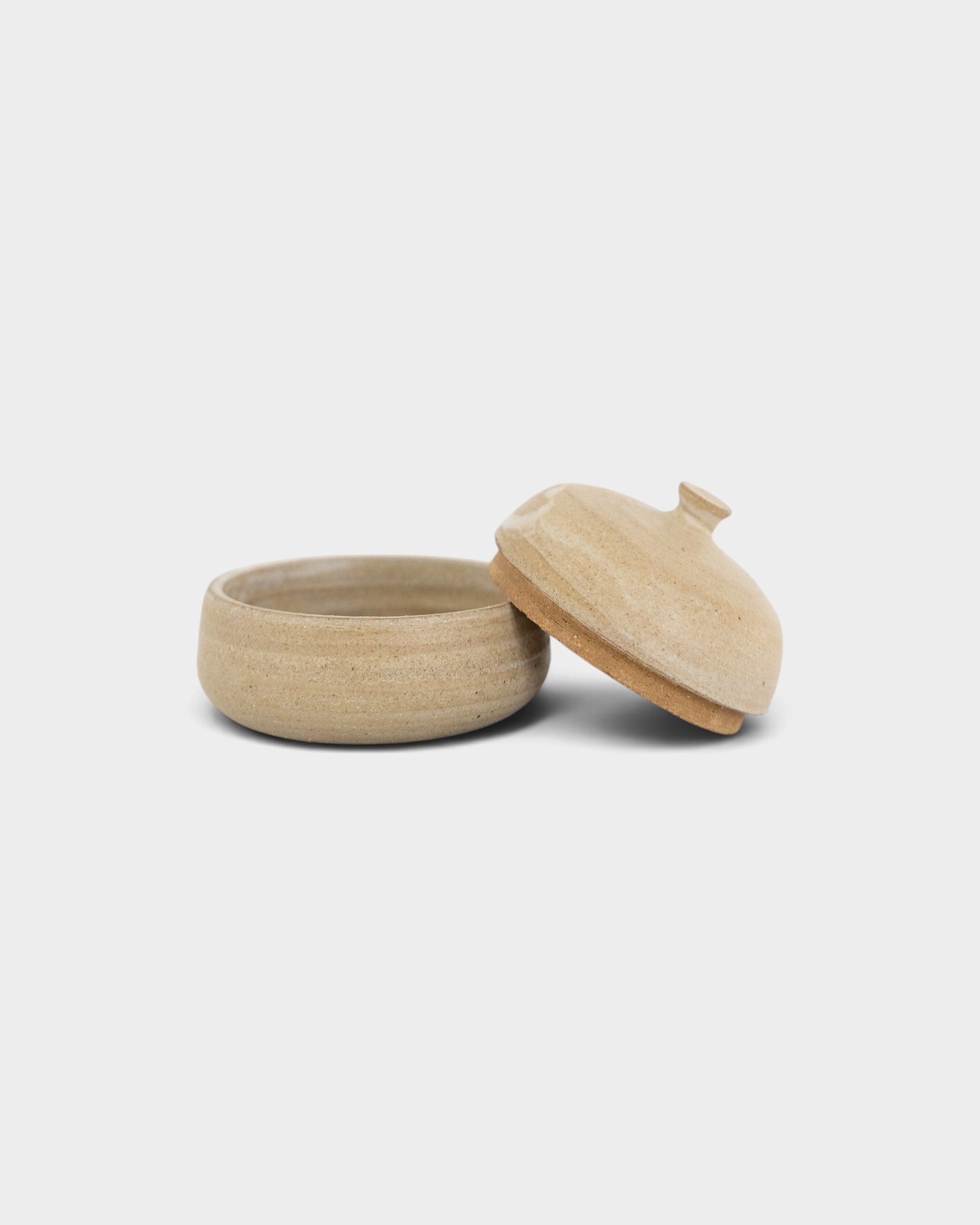 JONES + CO large handthrown ceramic jar in a natural beige finish with a matching lid on a plain background