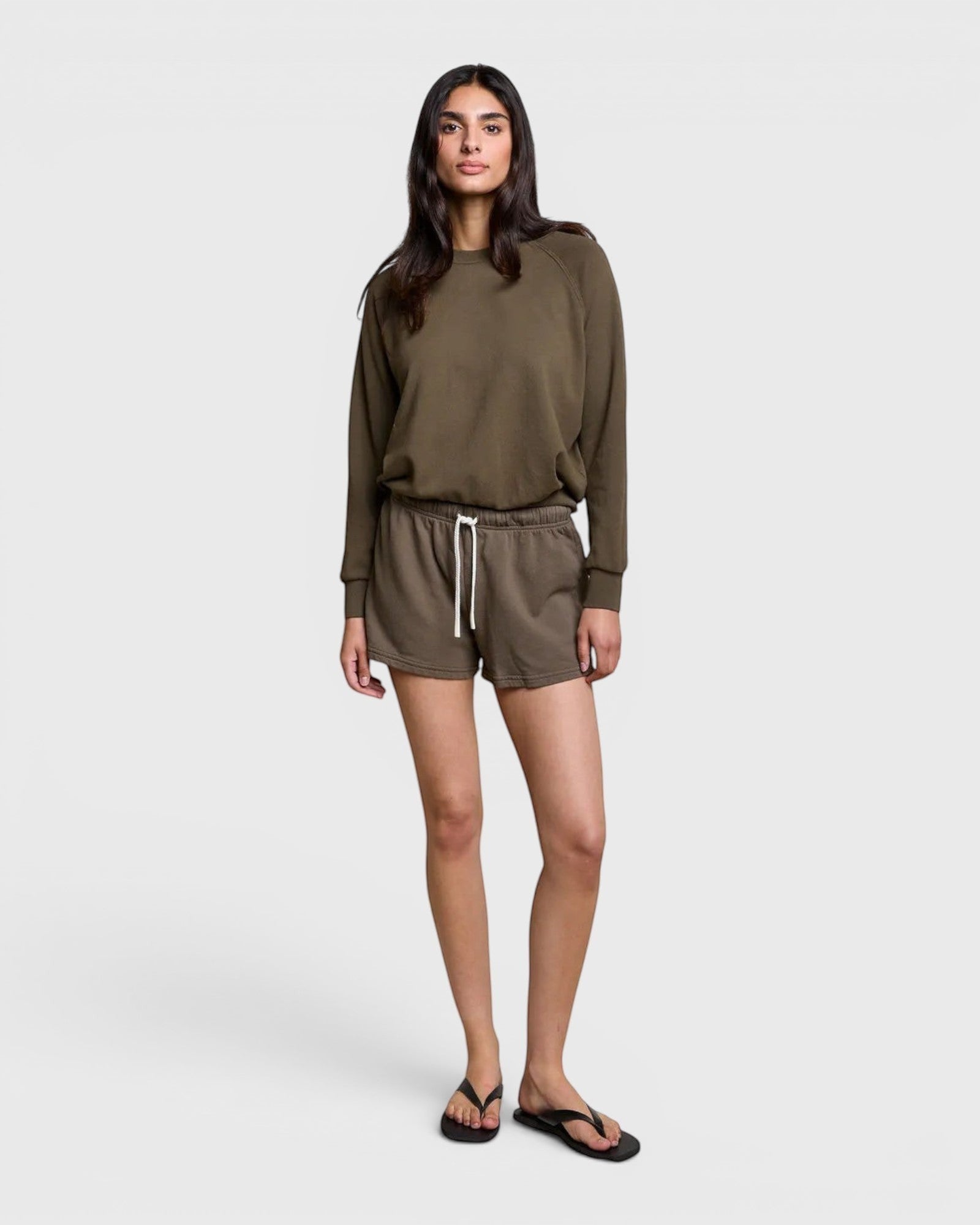 JONES + CO Layla dark olive French terry lounge shorts with elastic waistband and raw edge hem on a model