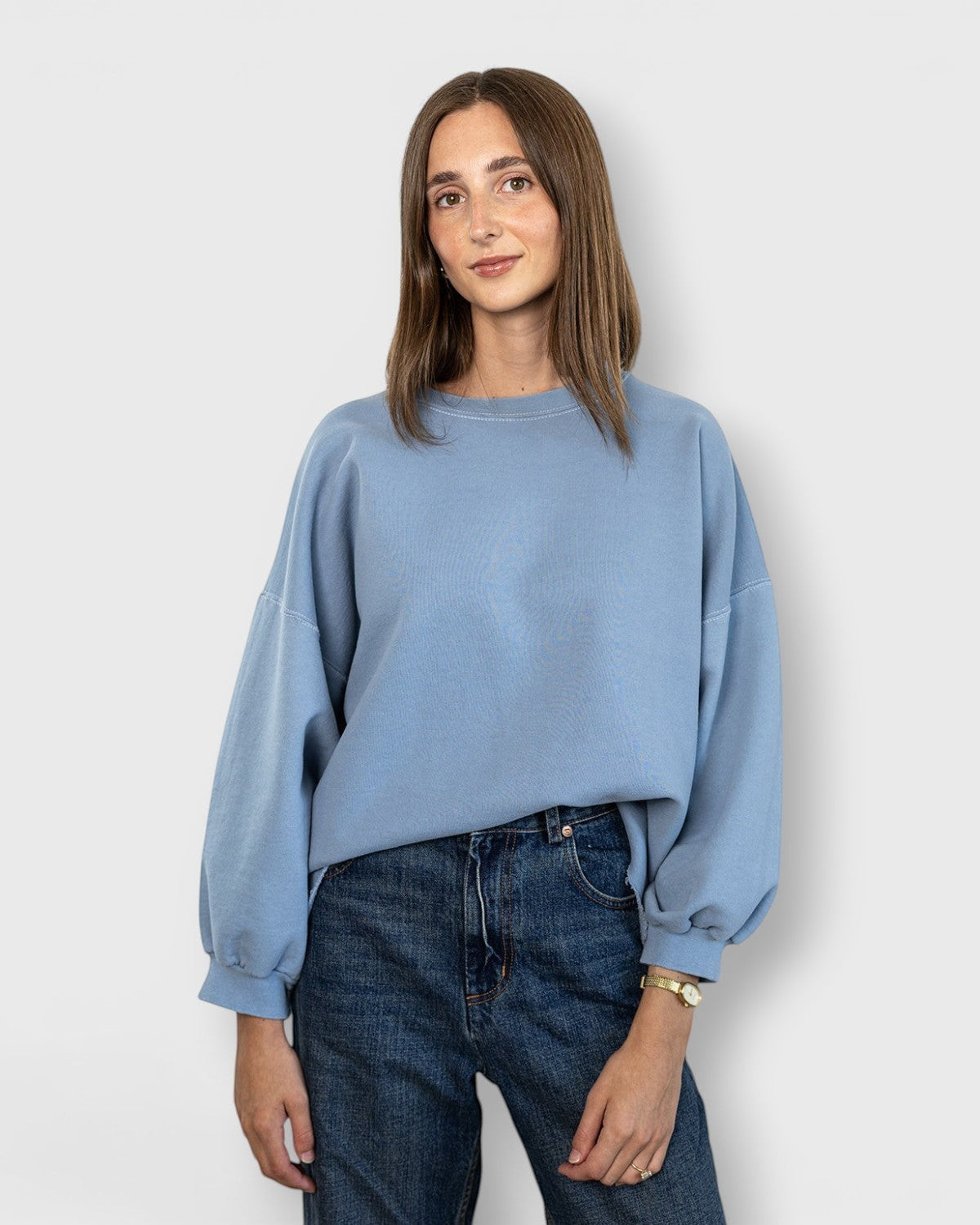 JONES + CO light blue crewneck sweatshirt with drop shoulders and raw edge hem worn by a woman