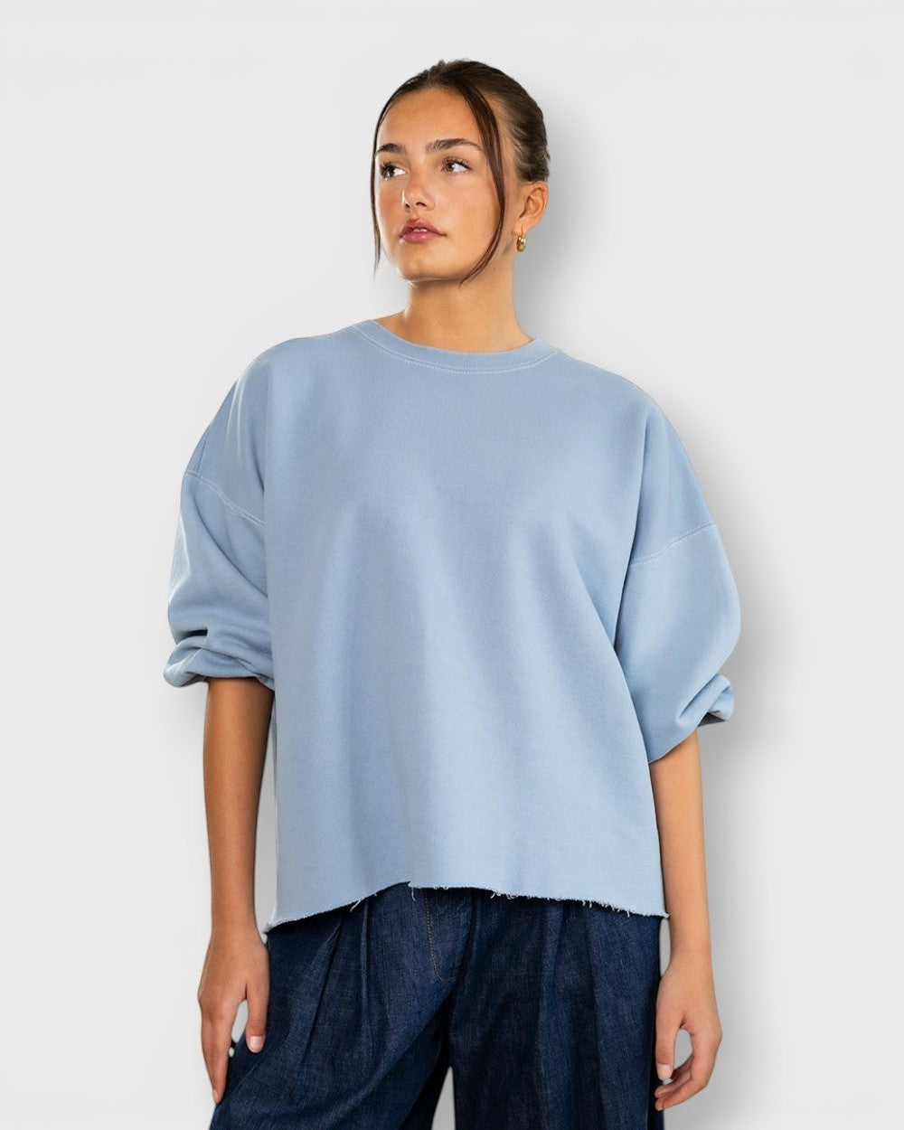 JONES + CO light blue crewneck sweatshirt with drop shoulders, cropped sleeves, and a raw edge hemline.