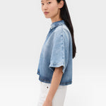 JONES + CO Lotus shirt in Malibu Wash denim, featuring an open collar and wide dolman sleeves. Relaxed fit, cropped length.