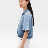 JONES + CO Lotus shirt in Malibu Wash denim, featuring an open collar and wide dolman sleeves. Relaxed fit, cropped length.