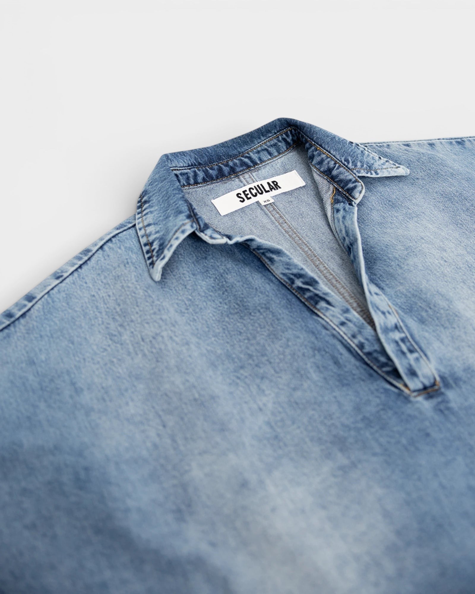 JONES + CO Lotus shirt in Malibu Wash light blue denim, featuring an open collar and wide dolman sleeves.