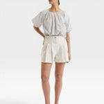 JONES + CO light blue cropped Lotus top with short sleeves, gathered cuffs, and drawstring waist. Features French knot embroidery.