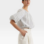 JONES + CO light blue cropped blouse with short sleeves, gathered cuffs, and French knot embroidery.