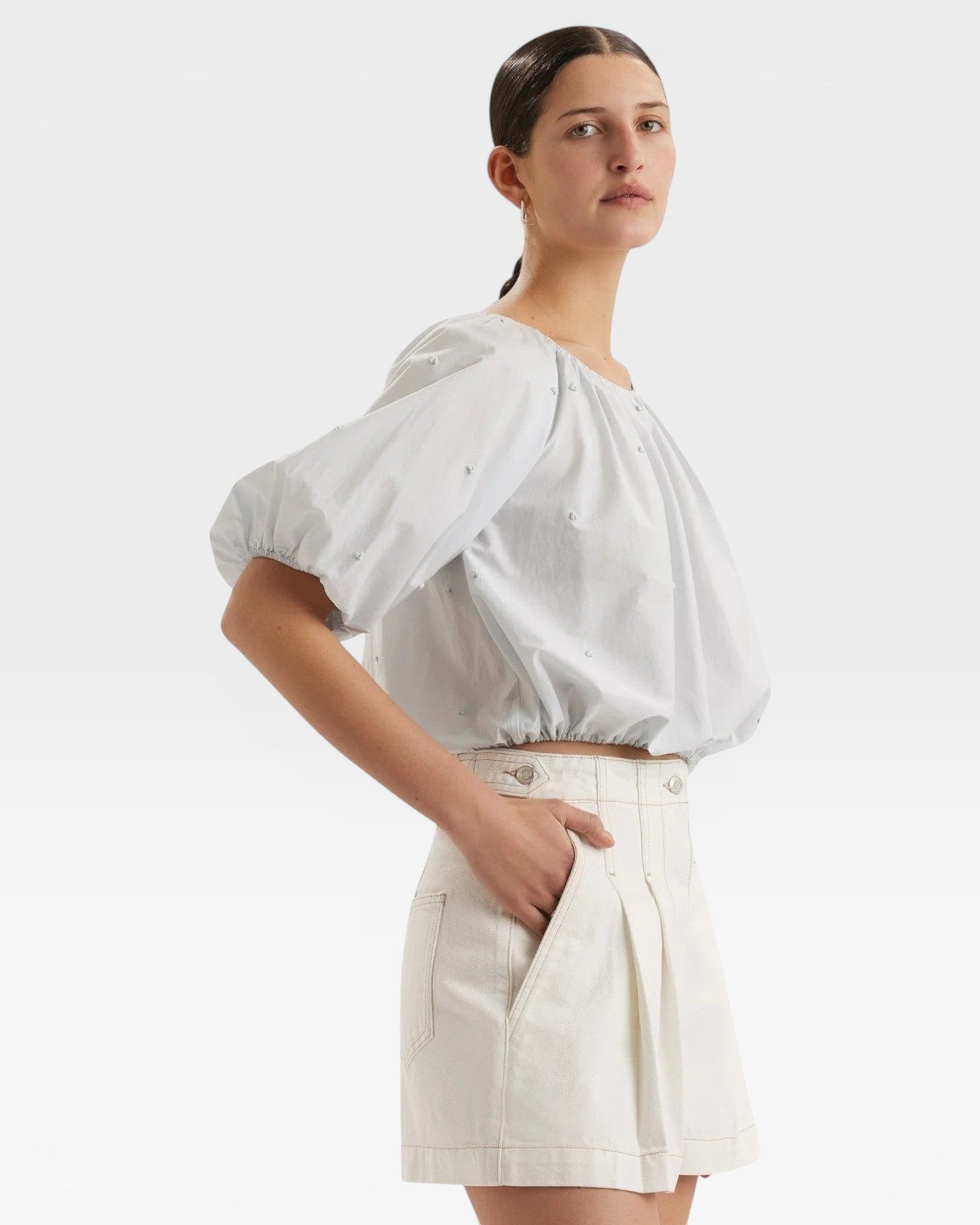 JONES + CO light blue cropped blouse with short sleeves, gathered cuffs, and French knot embroidery.