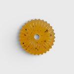 JONES + CO lülala basil and mandarin soap bar with calendula petals in a circular scalloped shape on a white background