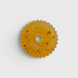 JONES + CO lülala basil and mandarin soap bar with calendula petals in a circular scalloped shape on a white background