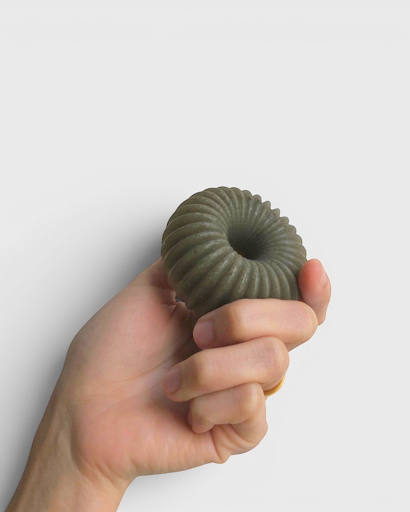 JONES + CO lülala lavender and pink grapefruit soap bar with barley, featuring a green ribbed ring shape in hand.