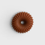JONES + CO lülala gardenia and frankincense soap bar in a circular, fluted pink clay design.