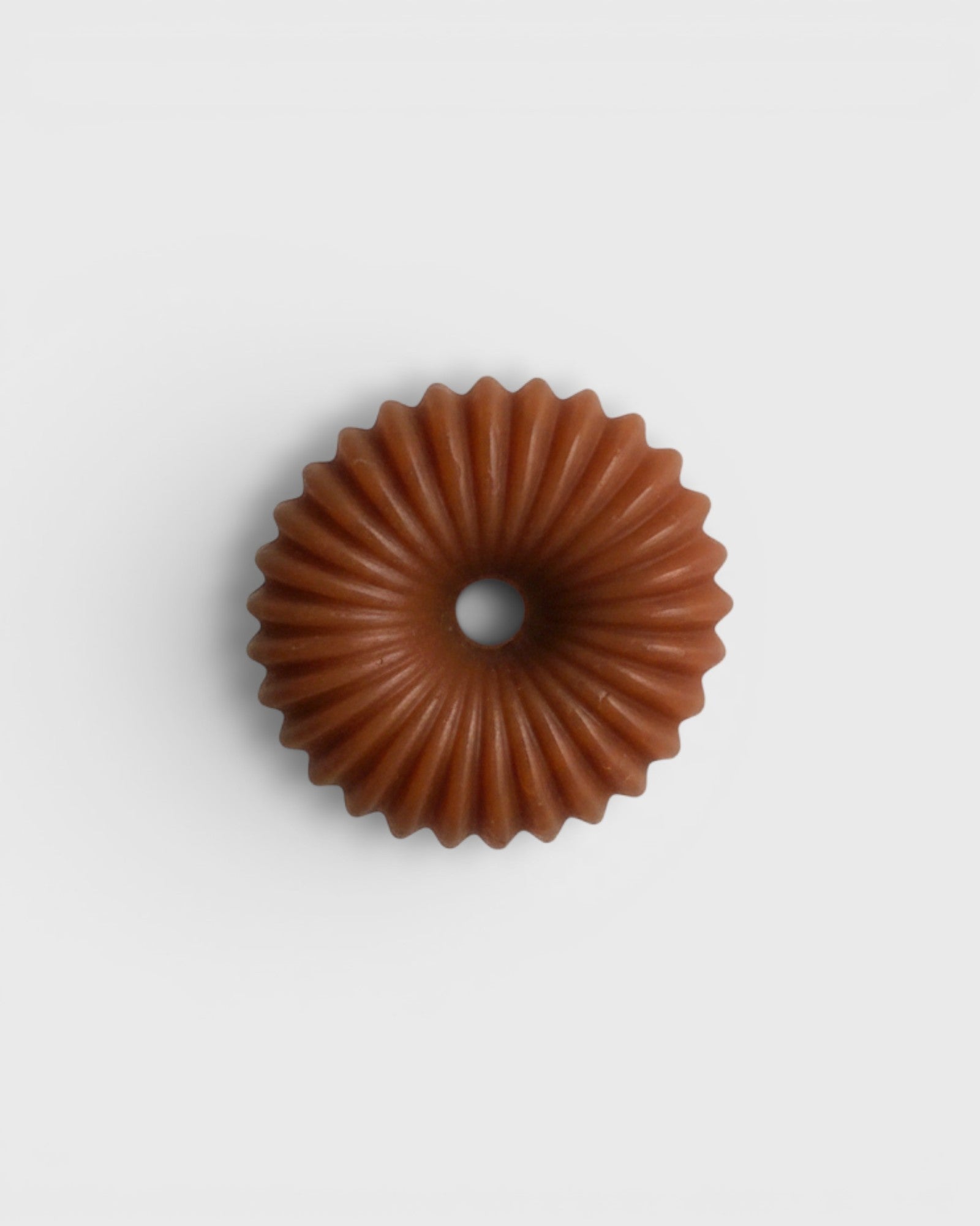 JONES + CO lülala gardenia and frankincense soap bar in a circular, fluted pink clay design.