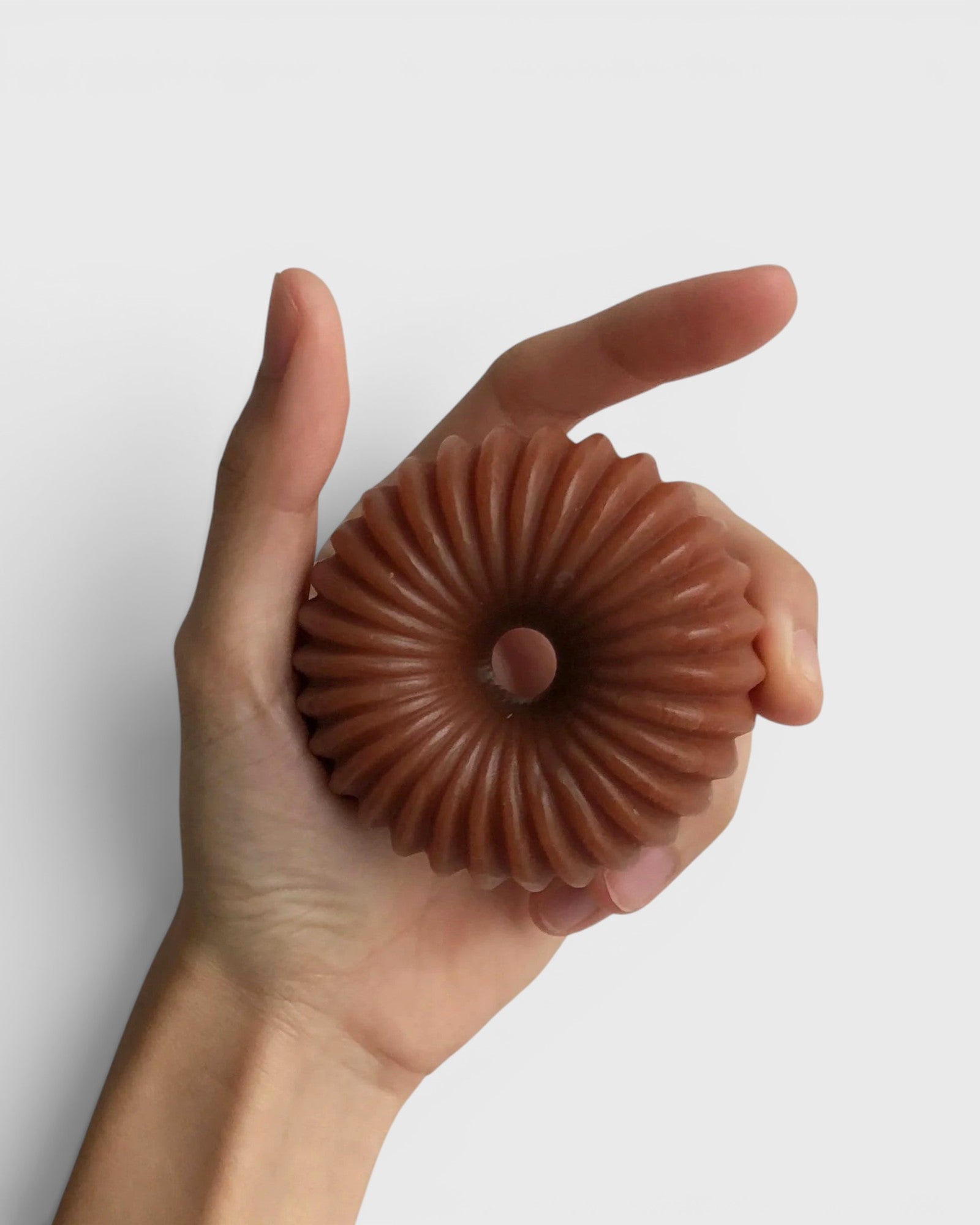 JONES + CO lülala gardenia and frankincense soap bar in a hand, featuring a pink clay fluted ring design.