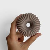 JONES + CO lülala ylang ylang and rosemary soap bar with a unique ribbed circular design held in a hand
