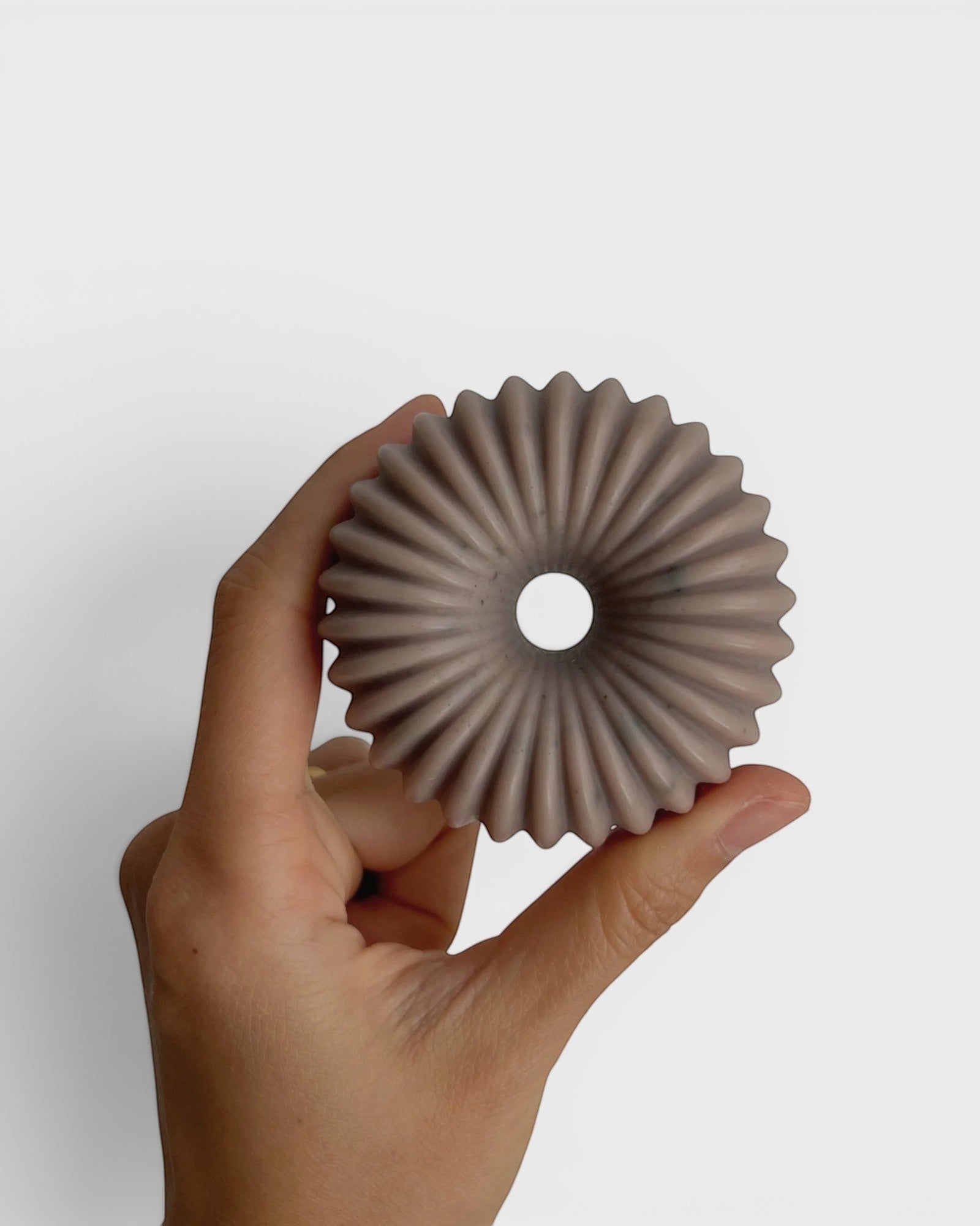 JONES + CO lülala ylang ylang and rosemary soap bar with a unique ribbed circular design held in a hand