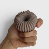 JONES + CO lülala ylang ylang and rosemary soap bar with a ribbed, circular design held in a hand.