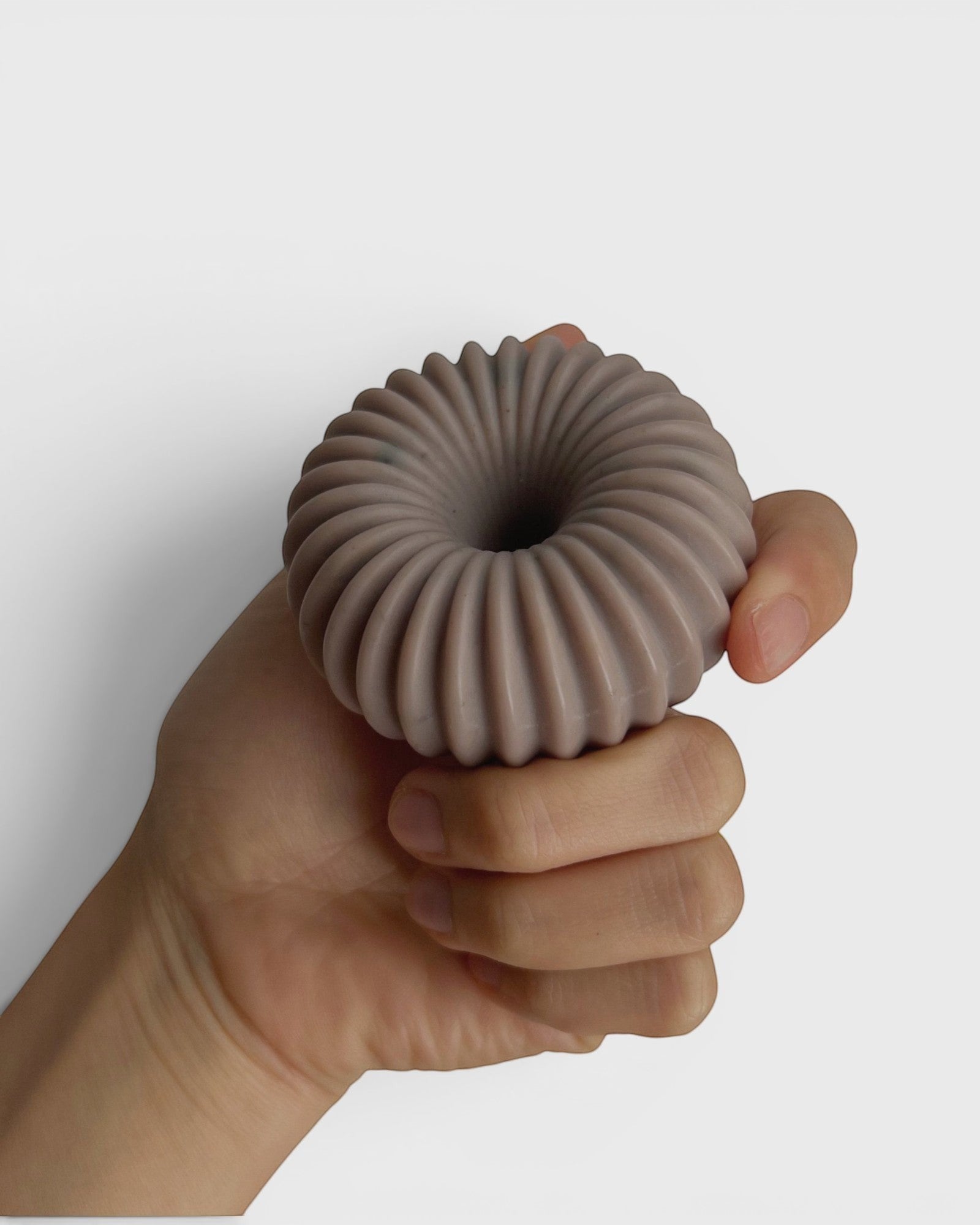 JONES + CO lülala ylang ylang and rosemary soap bar with a ribbed, circular design held in a hand.