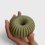 JONES + CO lülala hand-crafted soap bar in sage green with a ribbed, geometric donut shape held in a palm.